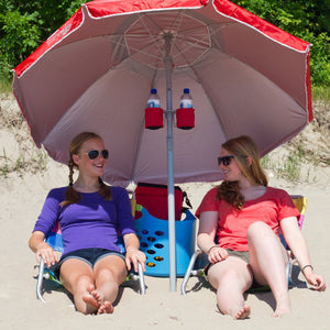 2 women sitting outside at beach under red wondershade